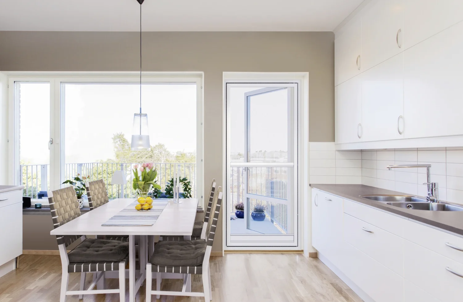 Moderne helle Küche mit Esstisch und großen Fenstern