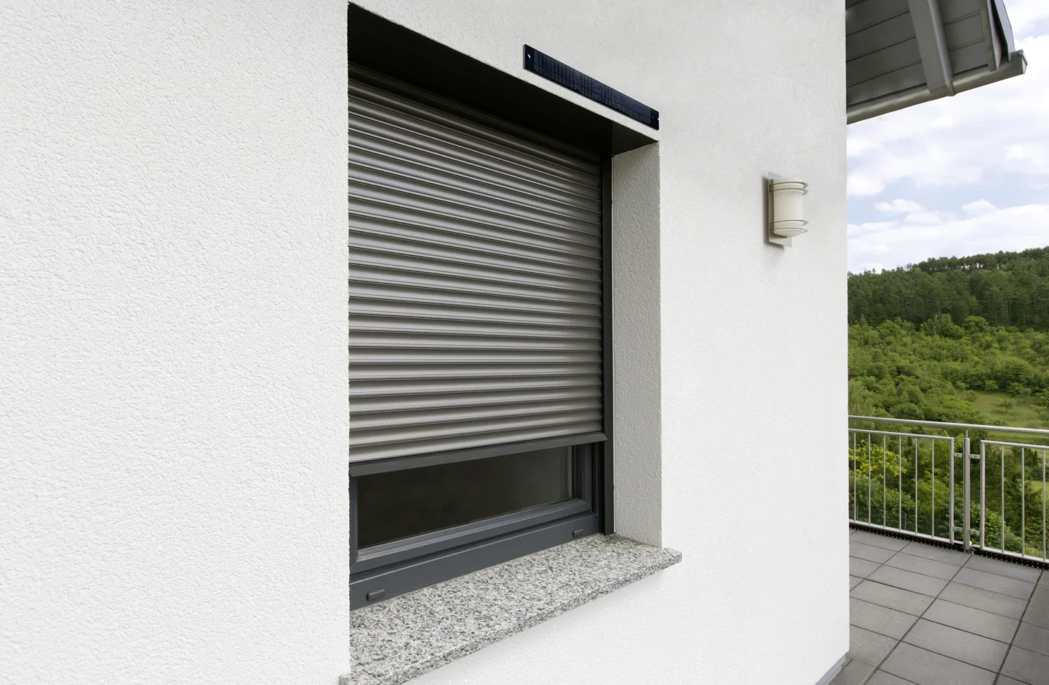 Geschlossenes Rollladenfenster mit weißer Wand